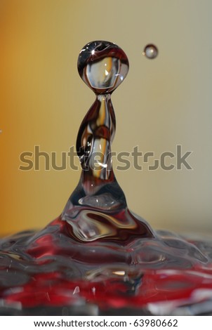 Water droplet rebound or splash with red reflections. Looks like a person.