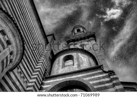The glory of God\'s Universe. The night sky above an Italian church. Black and white.