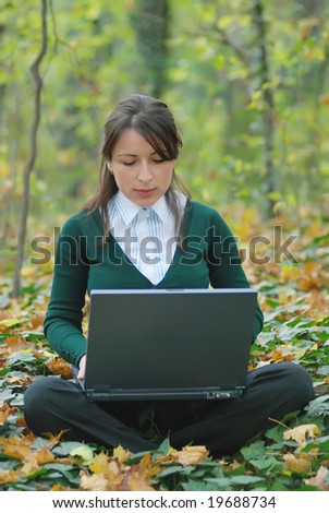 Young businesswoman working on laptop outdoor