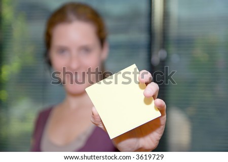 Receptionist shows you a sticky note. Shallow depth of field, emphasizing sharp focus on the note.