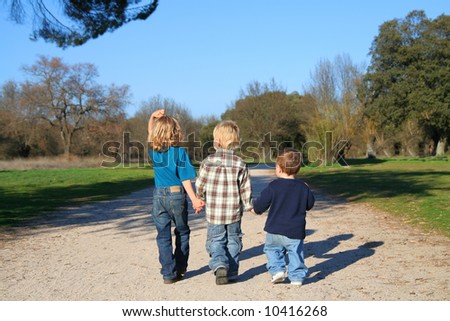 stock photo : Childhood happiness. Three Kids Holding Hands in a nature reserve