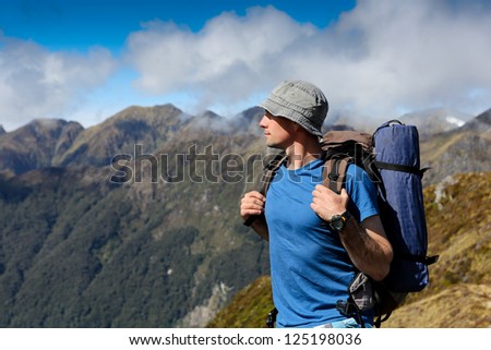 close up portrait of hiker looking at the horizon in the mountains on sunny day