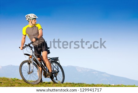 Young bright man on mountain bike