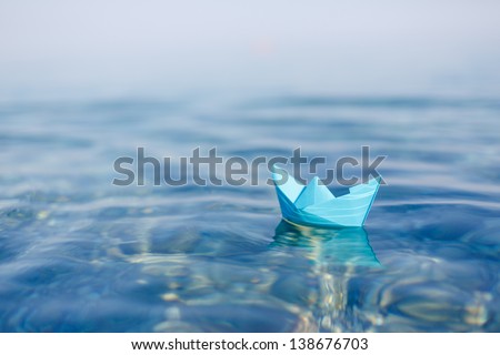 Paper Boat Sailing On Blue Water Surface