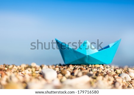 Blue paper boats on beach outdoors