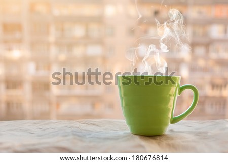 teaming coffee cup on a sunrise. window background