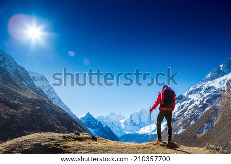 Active hiker hiking, enjoying the view, looking at mountain Himalaya landscape. mountaineering sport lifestyle concept