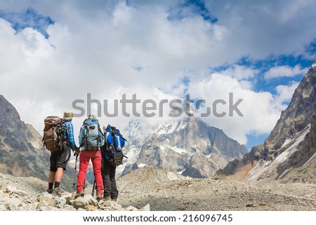 Hikers team and snow-capped mountain landscape