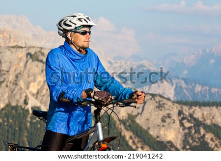 Cyclist with a Bike on the Beautiful Mountain Trail