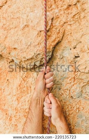 hand holding rope on rock background
