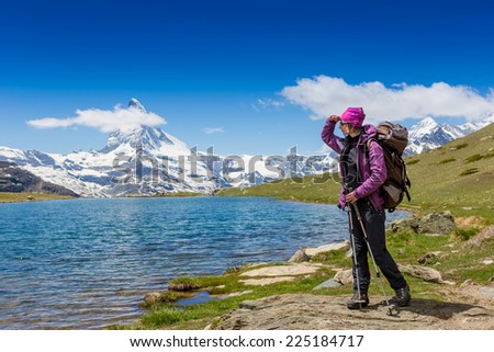 Alone female hiker among the mountains. European Alps. Swiss. Matterhorn view