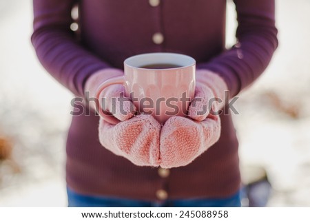 woman in mittens holding hot cup of tea. Winter inspiration