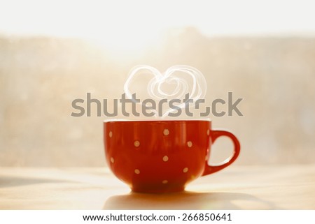 love and tea. heart silhouette from steaming hot cup on sunset