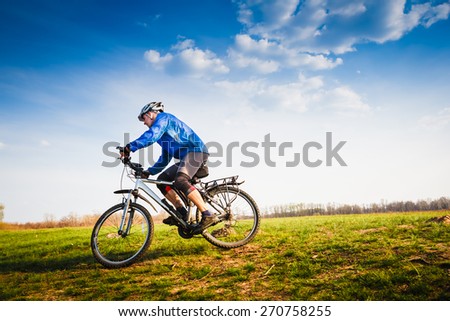 Cyclist Riding the Bike on the Beautiful Spring Trail