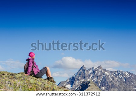 Woman Traveler with Backpack hiking in Mountains with beautiful summer landscape
