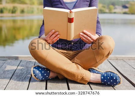 Close-up of female hands holding open book. Reading concept background