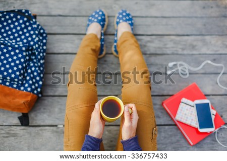 Lifestyle, vacation, education and people concept. Young hipster girl have a tea time outdoor