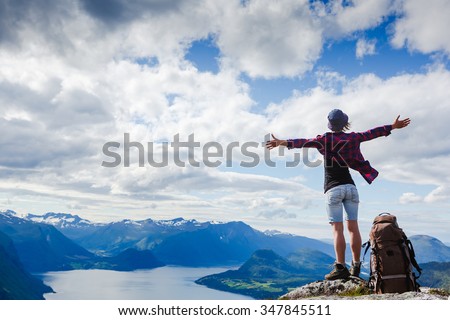 Happy hiker with her arms outstretched, freedom and happiness, achievement in mountains