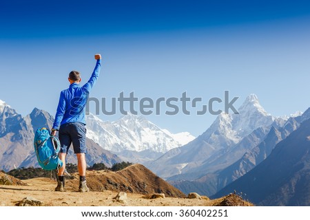 Winner / Success concept. Hiker cheering elated and blissful with arms raised in the sky after hiking. Everest base camp trek