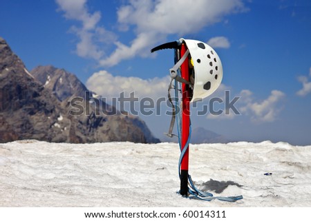 Climbing equipment in the mountains with snow and blue cloudy sky