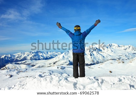 men at the top of a snowy mountain with his hands up