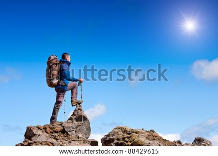 hiker at the top of a rock enjoy sunny day