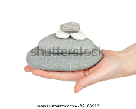 woman hand holding a stone tower isolated on white background