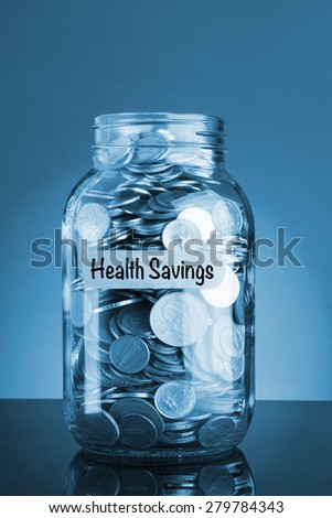 Health Savings concepts with coins in jar on blue background