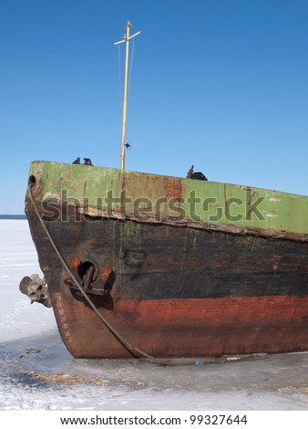 Old ship on the lake in winter