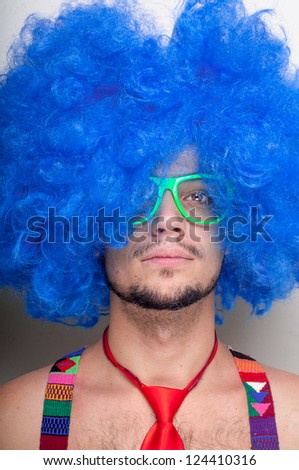 Funny guy naked with blue wig and red tie on green background