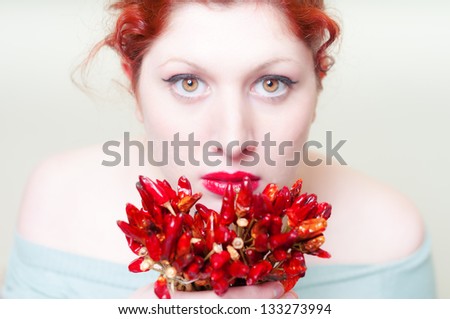 beautiful red hair and lips girl with red chillies on white background