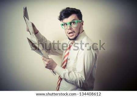 lost businessman with map on gray background