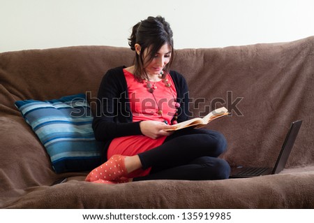 woman at home reading book on couch