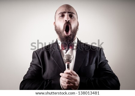funny elegant singer bearded on vignetting background