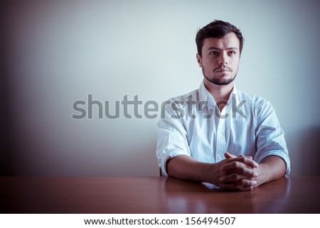 young stylish man with white shirt behind a table
