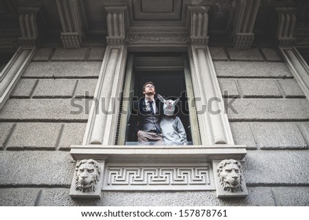 elegant attractive fashion hipster man with rabbit woman appeared at the window