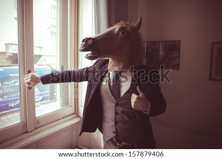 horse mask man in front of window at home