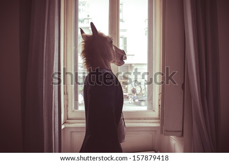 horse mask man in front of window at home