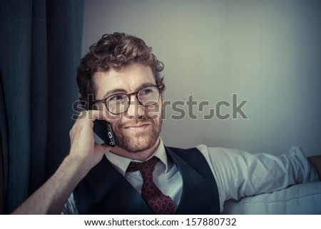 elegant attractive fashion hipster man on the phone at home