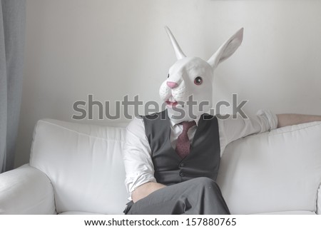 rabbit mask man sitting on sofa at home