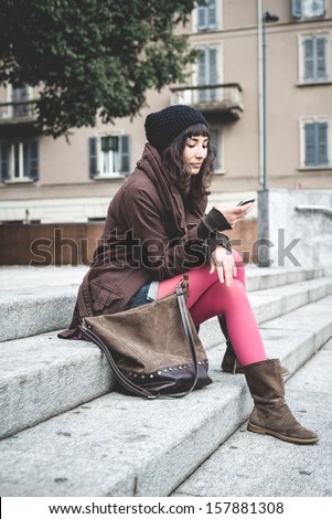 beautiful young woman on the phone in the city autumn
