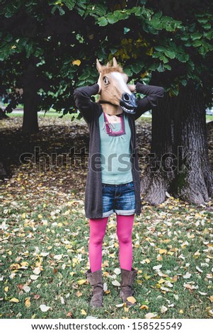 horse mask woman in the park autumn