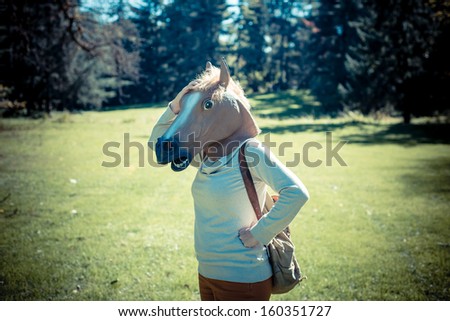 young hipster horse mask woman in the woodland autumn
