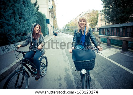 two friends woman on bike in urban contest