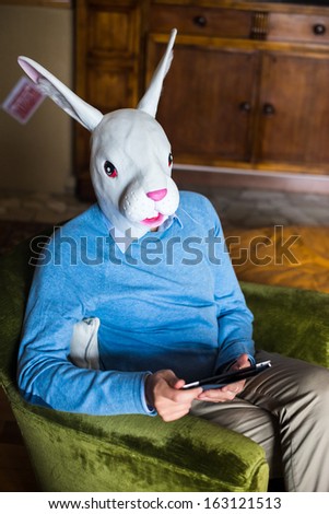 elegant business multitasking rabbit mask man using devices at home