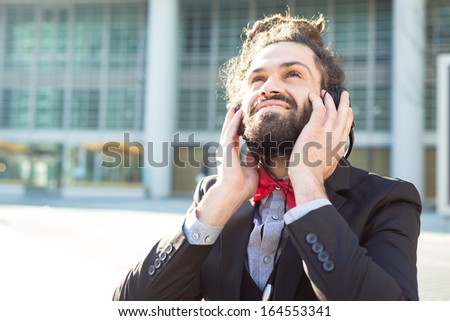 Stylish elegant dreadlocks businessman listening to music in business landscape