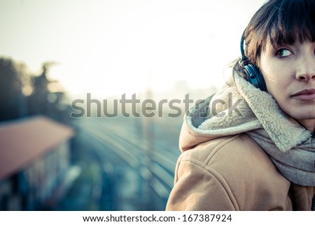 Beautiful Young Woman Listening To Music Headphones In The City Winter