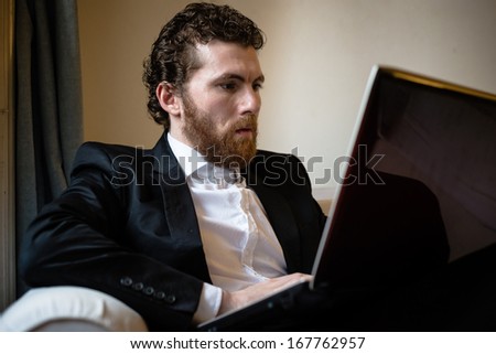 handsome bearded hipster elegant man using laptop