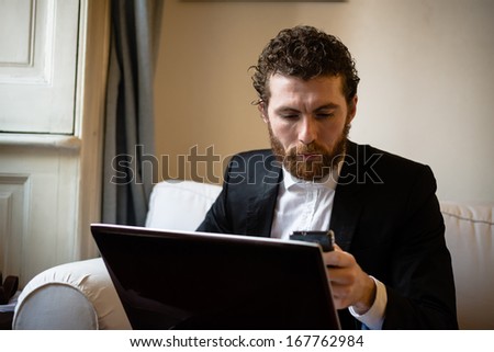 handsome bearded hipster elegant man using laptop