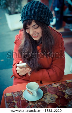 beautiful woman red coat cellphone sitting bar winter